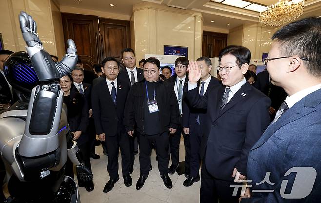 이재명 대통령이 7일 중국 상하이 국제회의중심에서 열린 한중 벤처스타트업 서밋 행사에서 중국 기업 엣지봇의 휴머노이드 로봇을 살펴보고 있다. 2026.1.7/뉴스1 ⓒ News1 허경 기자