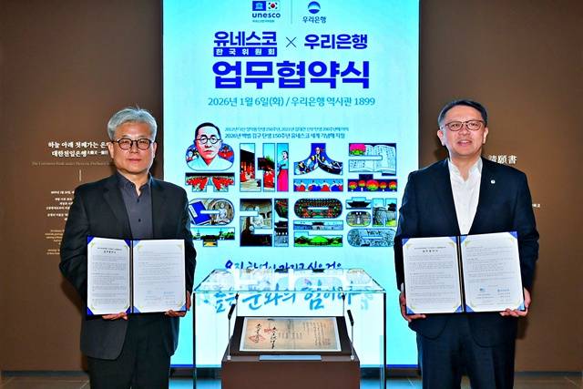 지난 6일 우리은행 역사관 '우리1899'에서 열린 협약식에서 정진완 우리은행장(오른쪽)과 윤병순 유네스코한국위원회 사무총장 직무대행이 대한천일은행 창립청원서 앞에서 기념촬영을 하고 있다. /우리은행