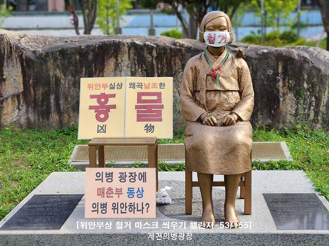 A statue of a girl symbolizing the victims of Japanese wartime sexual slavery, euphemistically referred to as comfort women, located in Jecheon, North Chungcheong, is seen with a sign that reads "remove," installed by a far-right civic organization. [SCREEN CAPTURE]