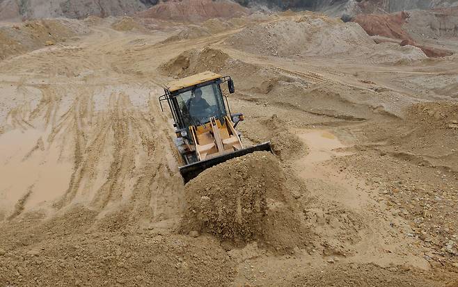 A labourer operates a bulldozer at a site of a rare earth metals mine at Nancheng county, Jiangxi province in China on March 14, 2012. [REUTERS/YONHAP]