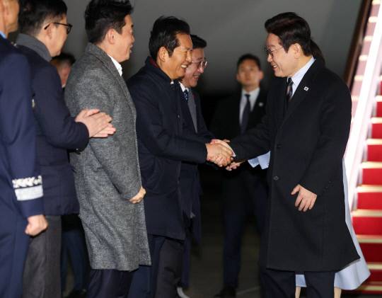 중국 국빈방문 일정을 마치고 귀국한 이재명 대통령이 7일 성남 서울공항에서 환영나온 더불어민주당 정청래 대표와 인사하고 있다. 연합뉴스