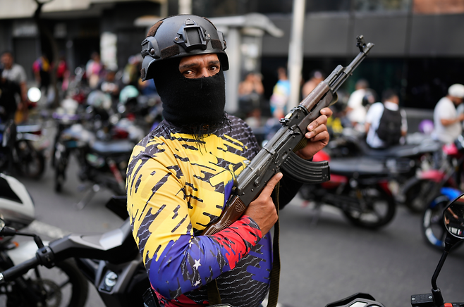 1월 5일, 베네수엘라 친정부 조직인 오토바이 갱단 ‘콜렉티보’ 조직원이 수도 카라카스에서 무장한 채 순찰 중이다. AP 뉴시스