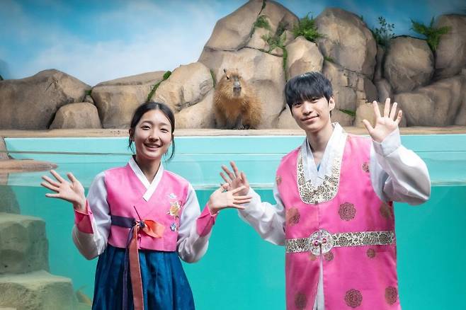 카피바라 수조 앞에서 포즈를 취하고 있는 아쿠아리스트들