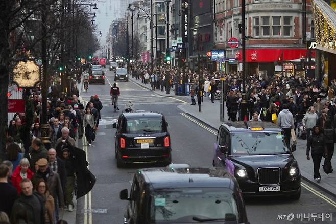 지난달 22일(현지 시간) 영국 런던에서 크리스마스를 앞둔 쇼핑객들이 런던의 대표 쇼핑 명소인 옥스퍼드 거리를 걷고 있다. /사진=AP·뉴시스