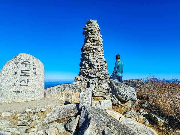 수도산 정상. 일년 반 동안 200개의 산을올랐다는 산꾼이 김천 쪽 산들을 바라보고 있다. 초겨울 날씨에 그의 셔츠는 완전히 땀에젖었다. 경북 김천과 경남 거창의 경계인데, 거창 표식은 없다.