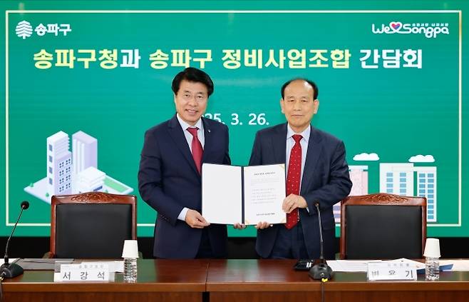 서강석(왼쪽) 송파구청장이 지난해 3월 변용기 송파구 정비사업조합 연합회장과 함께 재건축 건의서를 든 채 기념촬영을 하고 있다. 송파구 제공