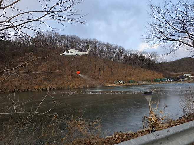▲ 경북 의성군 의성읍 팔성리 일대에서 10일 오후 산불 진화를 위해 헬기가 하천에서 담수한 뒤 야산 상공에서 공중 진화 작업을 벌이고 있다. 김동현 기자 jhass80@kyongbuk.com