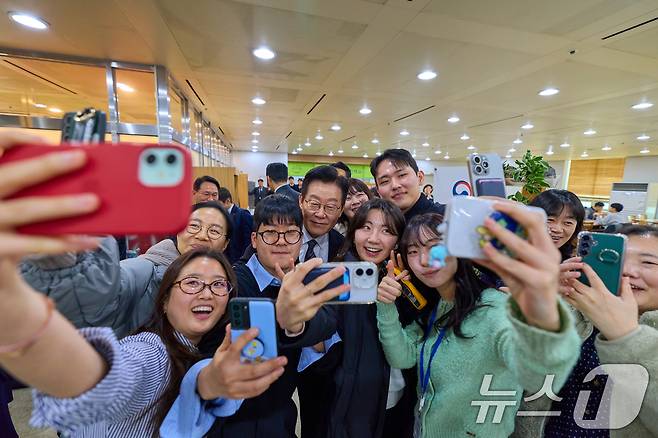 이재명 대통령이 정부 업무보고를 마친 뒤 서울 종로구 정부서울청사 별관 구내식당을 찾아 직원들과 기념촬영을 하고 있다. (대통령실 제공. 재판매 및 DB 금지) 2025.12.19/뉴스1 ⓒ News1 허경 기자