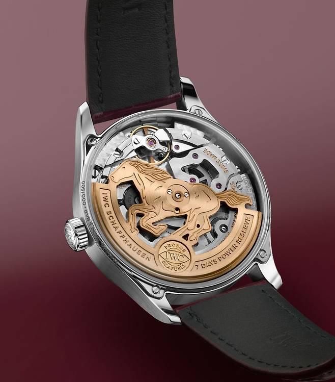 사파이어 케이스백을 통해 보이는 인하우스 칼리버 52011의 골드 로터에 2026년의 주인공인 말이 정교하게 각인되어 있다. IWC.