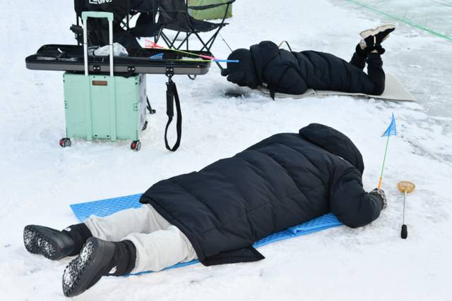 ▲ 개막 이틀째인 11일 제설 작업을 마친 화천산천어축제장에서 관광객들이 얼음낚시를 즐기고 있다.