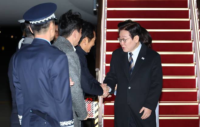 President Lee Jae Myung, far right, arrives at Seoul Air Base in Seongnam after completing a state visit to China on Jan. 7. First lady Kim Hea Kyung is behind him. [JOINT PRESS CORPS]