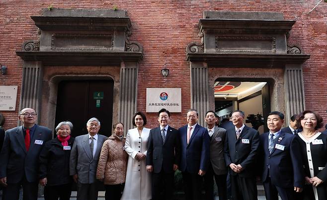 President Lee Jae Myung, center, accompanied by first lady Kim Hea Kyung, fifth from left, poses for a photo with descendants of independence fighters at the historic site of Korea's provisional government in Shanghai during Japan's 1910-45 colonial rule on Jan. 7, attending a ceremony marking the 100th anniversary of the building’s construction. [JOINT PRESS CORPS]