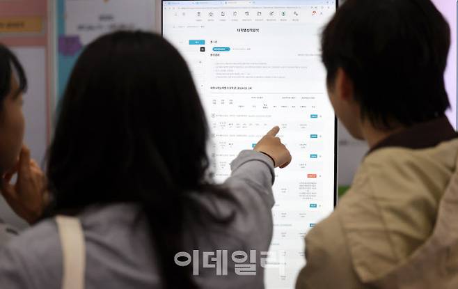 지난달 18일 서울 강남구 코엑스에서 열린 2026학년도 정시 대학입학정보박람회를 찾은 입시생들이 대학별 성적분석을 하고 있다. (사진=뉴시스)