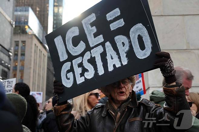 11일(현지시간) 미국 뉴욕시 맨해튼에서 도널드 트럼프 미국 행정부의 대내외 정책에 반대하는 '노 킹스'(No Kings) 시위가 열린 가운데, 한 시민이 이민세관단속국(ICE)을 규탄하는 손팻말을 들고 있다. 2025.01.11. ⓒ AFP=뉴스1 ⓒ News1 윤다정 기자