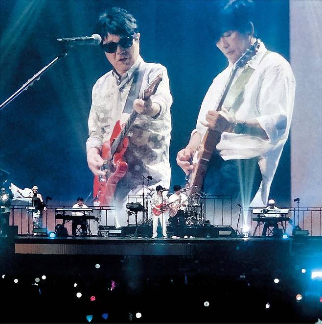 윤수정 기자 10일 서울 송파구 케이스포돔(올림픽체조경기장) 단독 공연 중 조용필이 노래 ‘미지의 세계’ 순서에서 기타를 메고 전속 밴드 ‘위대한 탄생’의 기타리스트 최희선(오른쪽)과 듀엣 연주를 선보이고 있다.