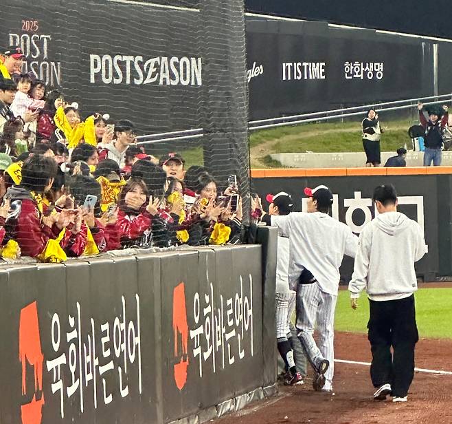 박해민(앞)과 임찬규(뒤)가 10월 31일 대전 한화생명볼파크에서 한국시리즈 우승을 차지한 뒤 그물망을 사이에 두고 팬들과 하이파이브를 하고 있다. 대전=이형석 기자 