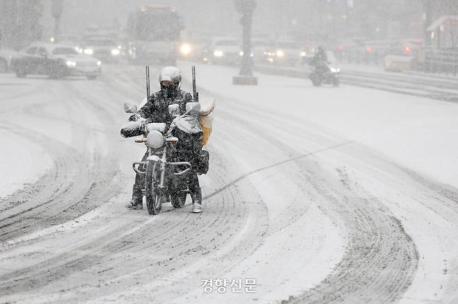 갑작스러운 폭설이 내린 지난해 2월6일 시민들이 눈을 맞으며 서울 세종로 사거리 인근을  지나고 있다. 문재원 기자