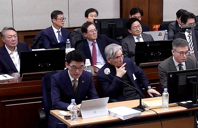 Lee Ha-sang (front left), attorney of former Defense Minister Kim Yong-hyun (front, second from left), reads from a document during the final court hearing for the insurrection charge of former President Yoon Suk Yeol (second row, left), and for seven of Yoon‘s closest aides, held at the Seoul Central District Court, Friday.  (Yonhap)