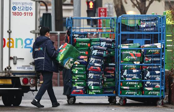 A Coupang deliveryperson moves packages at a warehouse in Seoul on Dec. 16, 2025. [NEWS1]