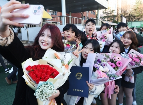 졸업식에서 꽃다발을 들고 사진 찍는 학생들의 모습. 연합뉴스