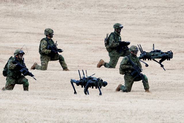 자위대, 로봇개와 훈련  : 11일 일본 도쿄에서 열린 육상자위대 제1공정단의 고공강하 훈련에서 병사들이 고스트 로보틱스의 군용 로봇 ‘비전60’과 함께 훈련하고 있다.  로이터 연합뉴스