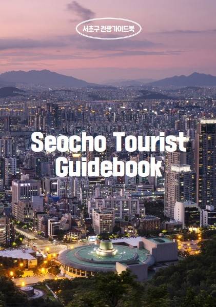서초 관광 가이드북 표지 이미지로, 도시 전경 위에 ‘Seocho Tourist Guidebook’이라는 흰색 영문 텍스트가 크게 쓰여 있는 사진이다. 흐릿한 하늘 아래 산과 도시의 야경이 펼쳐져 있다.