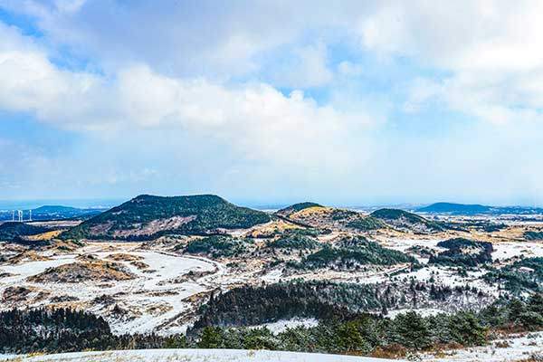 겨울날, 백약이오름에서 본 눈 덮인 좌보미오름. 왼쪽의 눈 덮인 곳이 여름이면 꽃천지로 바뀐다.