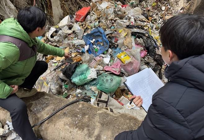 충남 천안시 공무원들이 지난 8일 천안의 한 폐기물 소각업체에서 쓰레기 더미를 뒤지며 수도권 생활폐기물 불법 반입 여부를 점검하고 있다. 천안시 제공