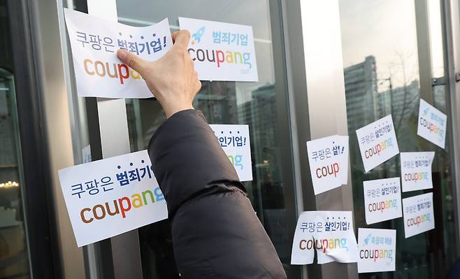 2025년 12월29일, 쿠팡 규탄 기자회견 참가자들이 쿠팡 본사에 항의 메시지를 붙이고 있다. ⓒ연합뉴스