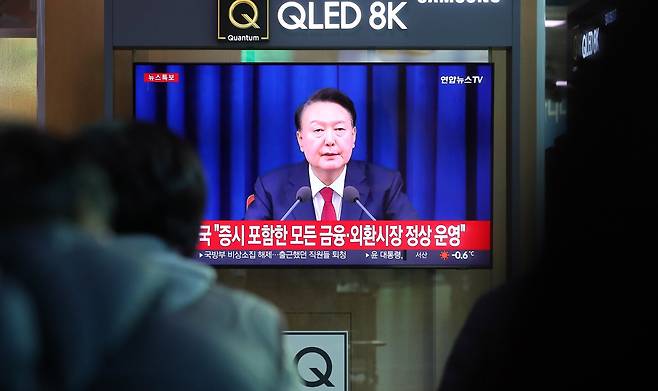 윤석열 대통령이 비상계엄 해제를 선언한 2024년 12월 4일 오전 서울역 대합실에서 시민들이 관련 뉴스를 보고 있다. 뉴시스