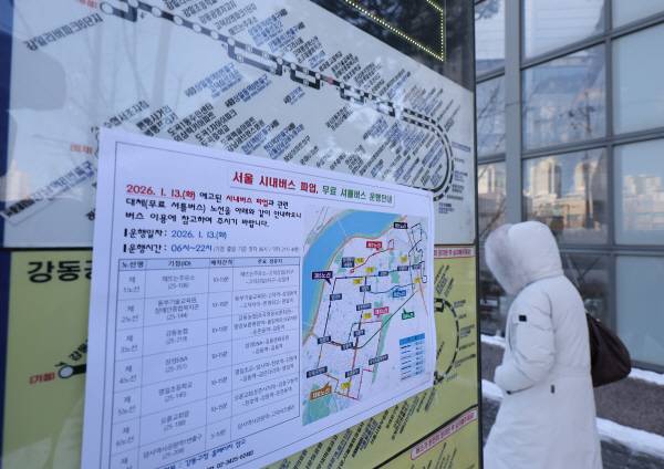 서울 시내버스 노동조합이 첫차부터 무기한 전면파업에 돌입한 13일 서울 강동구 명일동 한 버스 정류장에 무료 셔틀버스 운행안내문이 붙어 있다. 연합뉴스