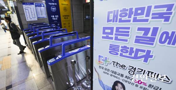 경기도형 교통패스 ‘더(The) 경기패스’에 정액권 기능이 추가되면서 서울시의 정액권 교통패스인 ‘기후동행카드’와 통합해야 한다는 목소리가 커지고 있다. 사진은 ‘더(The) 경기패스’ 홍보 입간판이 설치된 수원역에서 시민들이 개찰구를 통과하고 있다. /경인일보DB