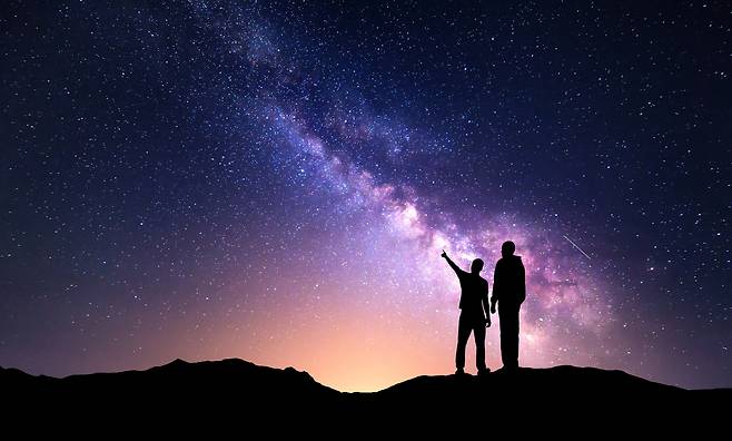천체여행 등 특별하고 이색적인 여행이 부각되고 있다. _클립아트 코리아 제공Milky Way with silhouette of a family and yellow city lights. Father and a son who pointing finger in night starry sky on the mountain. Night landscape. Beautiful Universe. Space. Travel background with sky full of stars