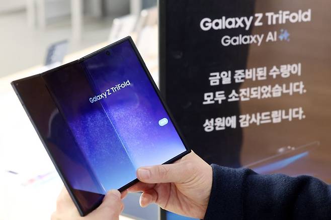 지난달 17일 삼성전자의 두 번 접는 폴더블 스마트폰 '갤럭시 Z 트라이폴드' 서울 중구 삼성스토어 롯데 본점에 물량 소진을 알리는 안내문이 놓여 있다.