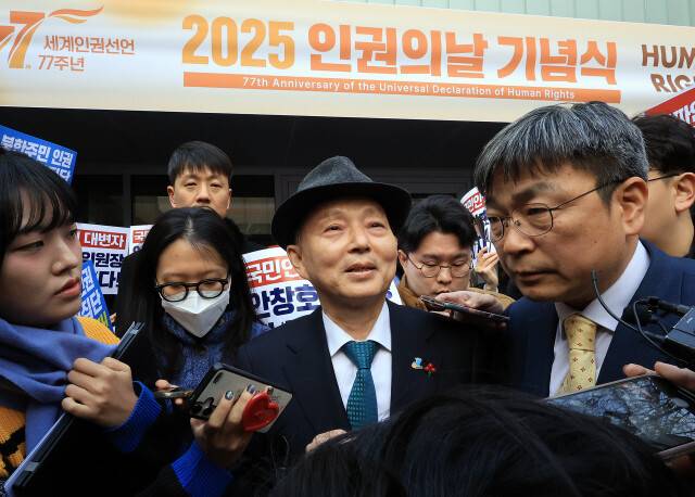 안창호 국가인권위원회 위원장이 10일 오전 서울 중구 안중근의사기념관에서 진행되는 2025 인권의 날 기념식장 앞에서 인권위바로잡기공동행동(공동행동) 등 사퇴를 촉구하는 시민단체에 의해 입장이 저지된 뒤 기자들에 둘러싸여 있다. 공동취재사진