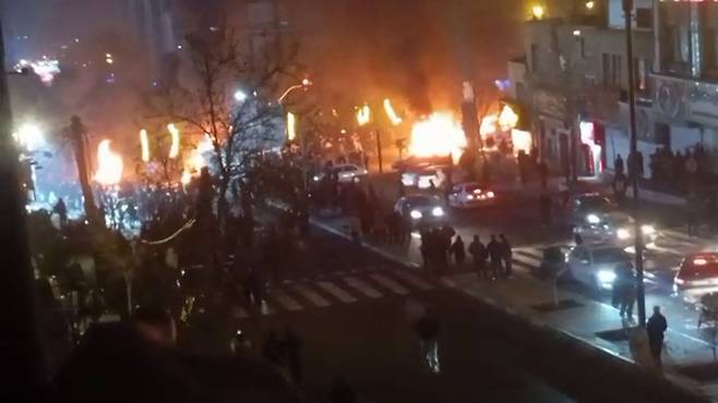지난 9일(현지시간) SNS를 캡처한 화면에는 이란 테헤란 사아다트아바드 광장에서 벌어진 시위 도중 차량들이 불타는 모습이 담겨 있다. AFP=연합뉴스