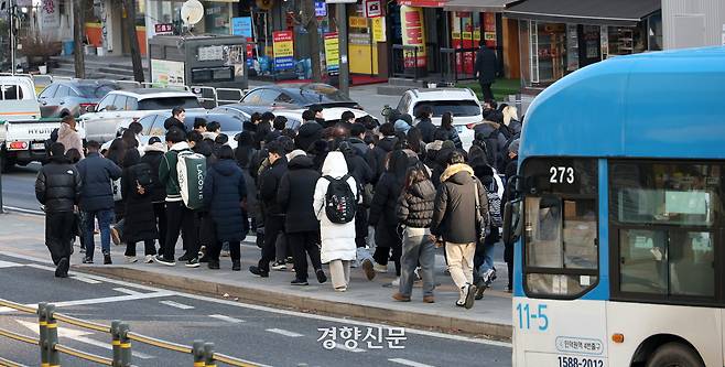서울 시내버스 노조의 무기한 전면 파업 이틀째인 14일 서울 동작구 사당역 인근 버스정류장에서  경기도에서 버스를 타고 지하철로 환승하려는 시민들이 횡단보도를 건너고 있다.  권도현 기자