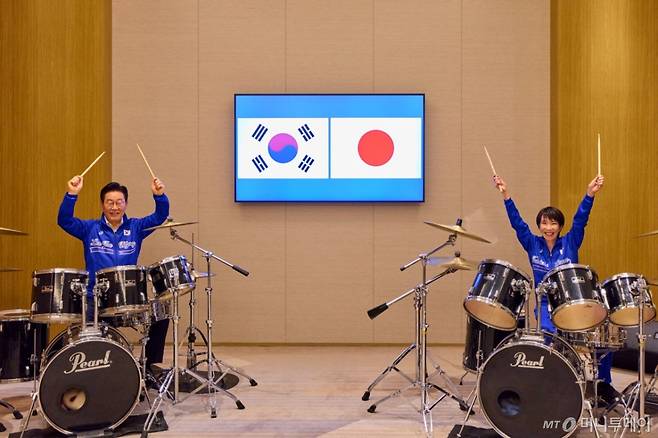 [나라=뉴시스] 고범준 기자 = 이재명 대통령이 다카이치 사나에 일본 총리와 함께 13일(현지 시간) 일본 나라현 회담장에서 일본 측이 마련한 푸른색 유니폼을 함께 착용하고 일본의 대표적인 악기 브랜드인 '펄' 드럼 앞에 나란히 앉아 즉석 드럼 합주를 선보이고 있다. (공동취재) 2026.01.13.
