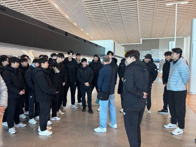 우리카드 선수단이 13일 인천국제공항에서 마우리시오 파에스 전 감독에게 응원의 메시지를 받고 있다. /사진=우리카드 배구단 제공