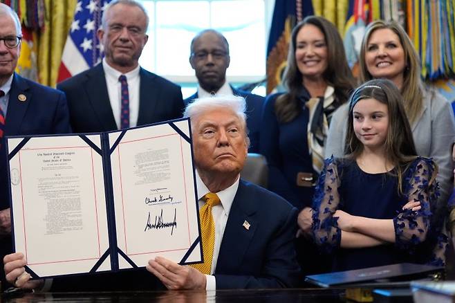 도널드 트럼프 미국 대통령이 14일(현지시간) 엔비디아의 인공지능(AI) 칩 'H200'처럼 미국으로 수입됐다가 재수출되는 반도체에 대해 25% 관세를 부과하는 행정명령에 서명했다. 반도체를 국가안보 품목으로 규정한 조치로, 향후 반도체 전반으로 관세 적용을 확대할 전망이다. 이날 트럼프 대통령이 워싱턴DC 백악관 집무실에서 공립학교들이 학생들에게 일반우유를 제공할 수 있게 하는 내용의 상원 통과 법안에 서명한 뒤 이를 들어 보이고 있다. AP연합뉴스