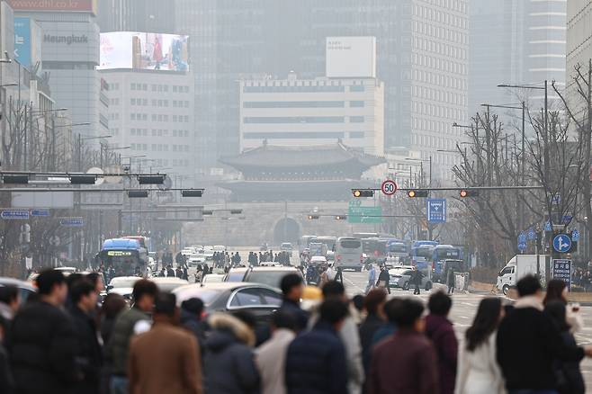 People are seen crossing a street in central Seoul during "bad" fine dust levels on Dec. 29, 2025. [NEWS1]