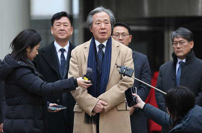 Jung Ki-suck, chairman of the National Health Insurance Service, speaks to reporters on Jan. 15 at the Seoul High Court in Seocho District, southern Seoul, about the NHIS’s loss in an appeals court ruling in its large-scale damages lawsuit against major tobacco companies. [YONHAP]