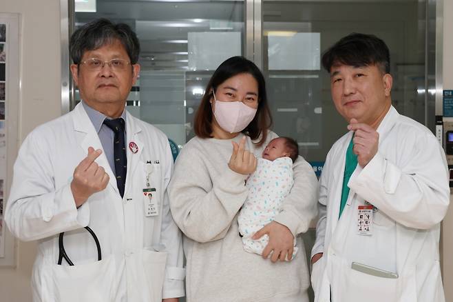 서울아산병원은 심장 크기가 엄지손가락만한 저체중아의 복잡한 선천성심장병을 생후 8일 만에 치료하는 데 성공했다. 사진은 수술을 집도한 윤태진 서울아산병원 소아심장외과 교수(왼쪽)와 퇴원을 앞둔 이준이 어머니와 이준이의 모습. /사진제공=서울아산병원