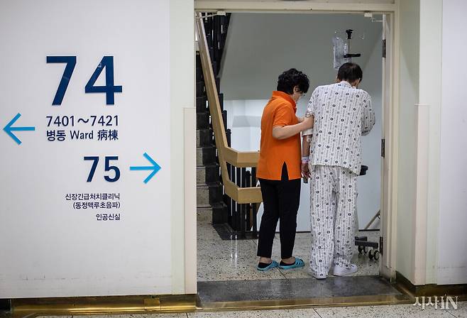 한 대학병원 병실 복도에서 간병사가 환자를 부축해 이동하고 있다. ⓒ시사IN 포토