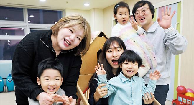 장경식 기자지난 14일 경기도 성남 한화비전의 직장 어린이집 놀이방에서 직원들과 자녀가 환하게 웃으며 포즈를 취하고 있다. 한화비전은 직원들이 가정을 돌보며 일할 수 있도록 유연 근무제, 난임 휴가 등 다양한 제도를 운영하고 있다.