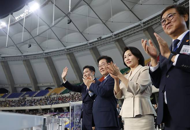 President Lee Jae Myung and First Lady Kim Hea Kyung welcome the athletes’ delegation as it enters the opening ceremony of the National Sports Festival at Busan Asiad Main Stadium on Oct. 17, 2025. From left are Ryu Seung-min, president of the Korea Sports and Olympic Committee; President Lee; First Lady Kim; and Choi Hwi-young, minister of culture, sports and tourism. [YONHAP]