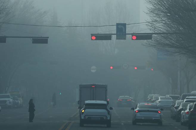Vehicles wait for the green light on a street in Gwangju as fine dust caused smog on Jan. 16. [NEWS1]