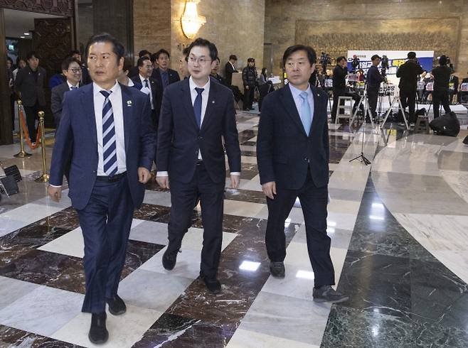 2차 종합특검법 가결 시킨 뒤 본회의장 나서는 정청래 대표 - 더불어민주당 정청래 대표(왼쪽)와 황명선 최고위원(오른쪽), 김동아 의원을 비롯한 의원들이 16일 국회에서 열린 2026년 1월 임시회 1차 본회의에서 2차 종합특검법을 처리한 뒤 본회의장을 떠나고 있다.  정 대표의 뒤편에는 2차 특검법 처리에 반대해 단식에 들어간 국민의힘 장동혁 대표와 의원 당직자들이 이를 지켜보고 있다.  연합뉴스