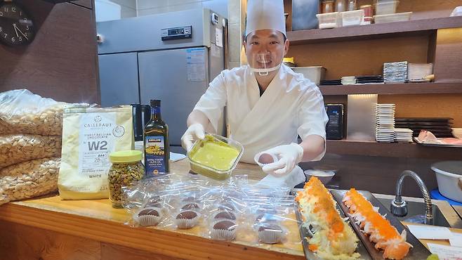 Park Sang-beom, who operates a sushi restaurant in Yangcheon District, western Seoul, shows a pistachio spread he made himself and some Dubai chewy cookies on Jan. 13. Park said his monthly sales rose more than 30 percent after adding the dessert. [COURTESY OF PARK]