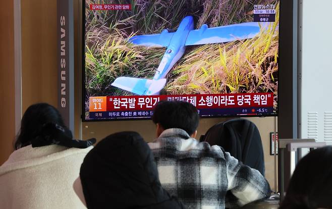 People watch a news broadcast of North Korea's announcement, which claims a South Korean unmanned aerial vehicle had infiltrated its airspace, in the waiting room of Seoul Station at Yongsan District, central Seoul, on Jan. 11. [YONHAP]